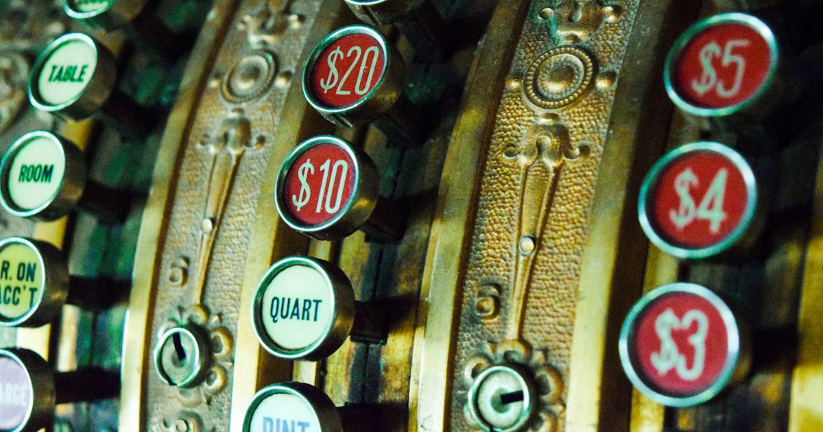 Close-up of the round keys on an antique cash register, marked $20, $10, $5, $4 and $3.