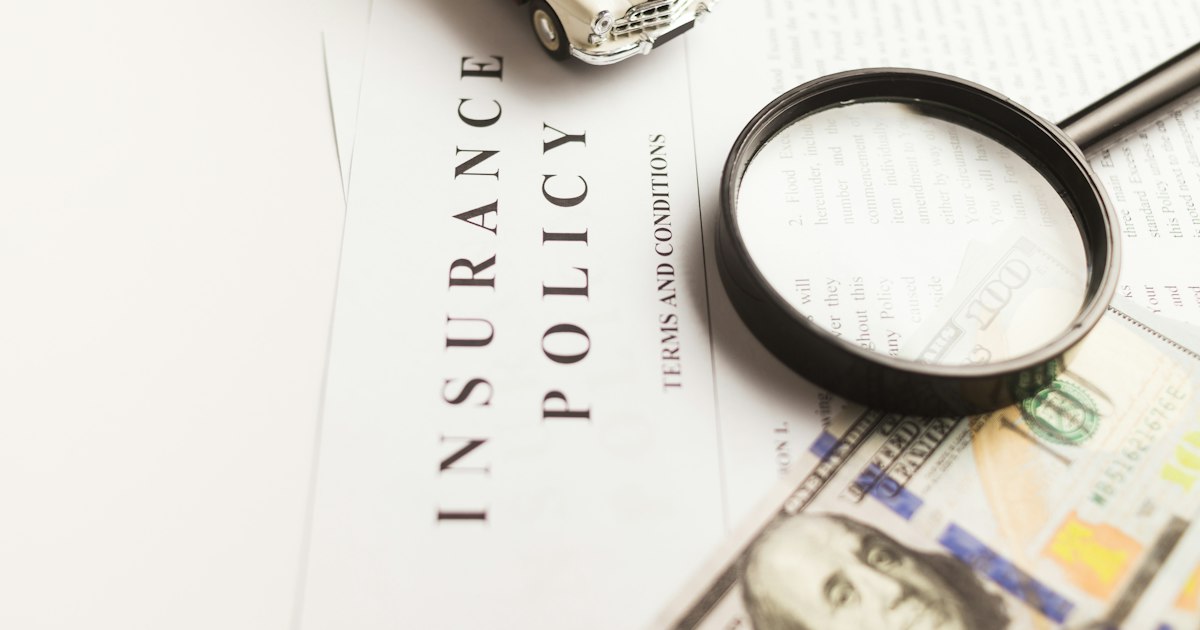 An insurance policy document headed Terms and Conditions, with a magnifying glass resting on the small print.
